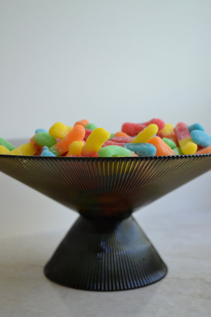 Glass bowl, footed bowl, serving bowl, fruit bowl, salad bowl, textured glass bowl, black glass bowl, eclectic decor, kitchenware zoomed in view.