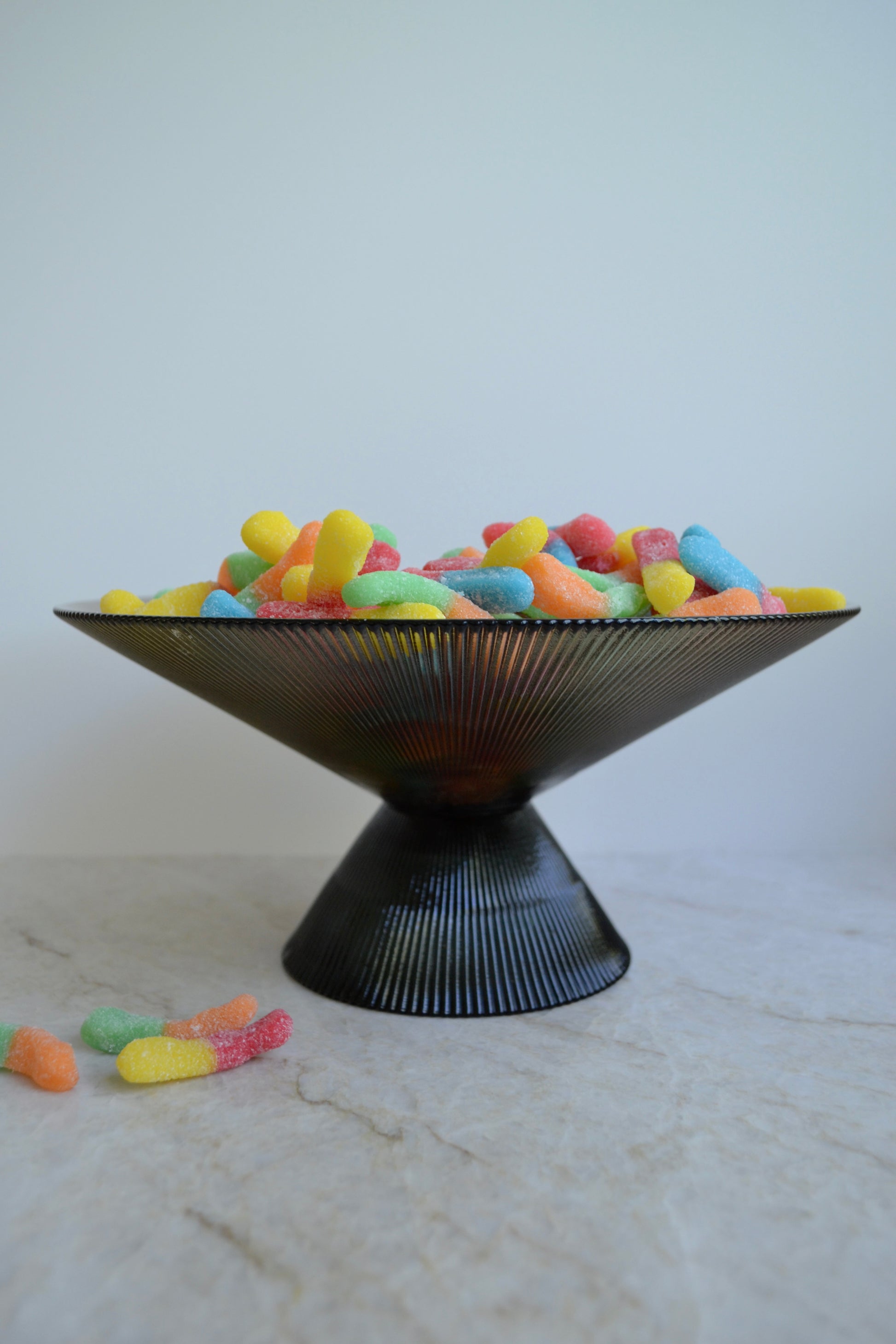 Glass bowl, footed bowl, serving bowl, fruit bowl, salad bowl, textured glass bowl, black glass bowl, eclectic decor, kitchenware zoomed out view.