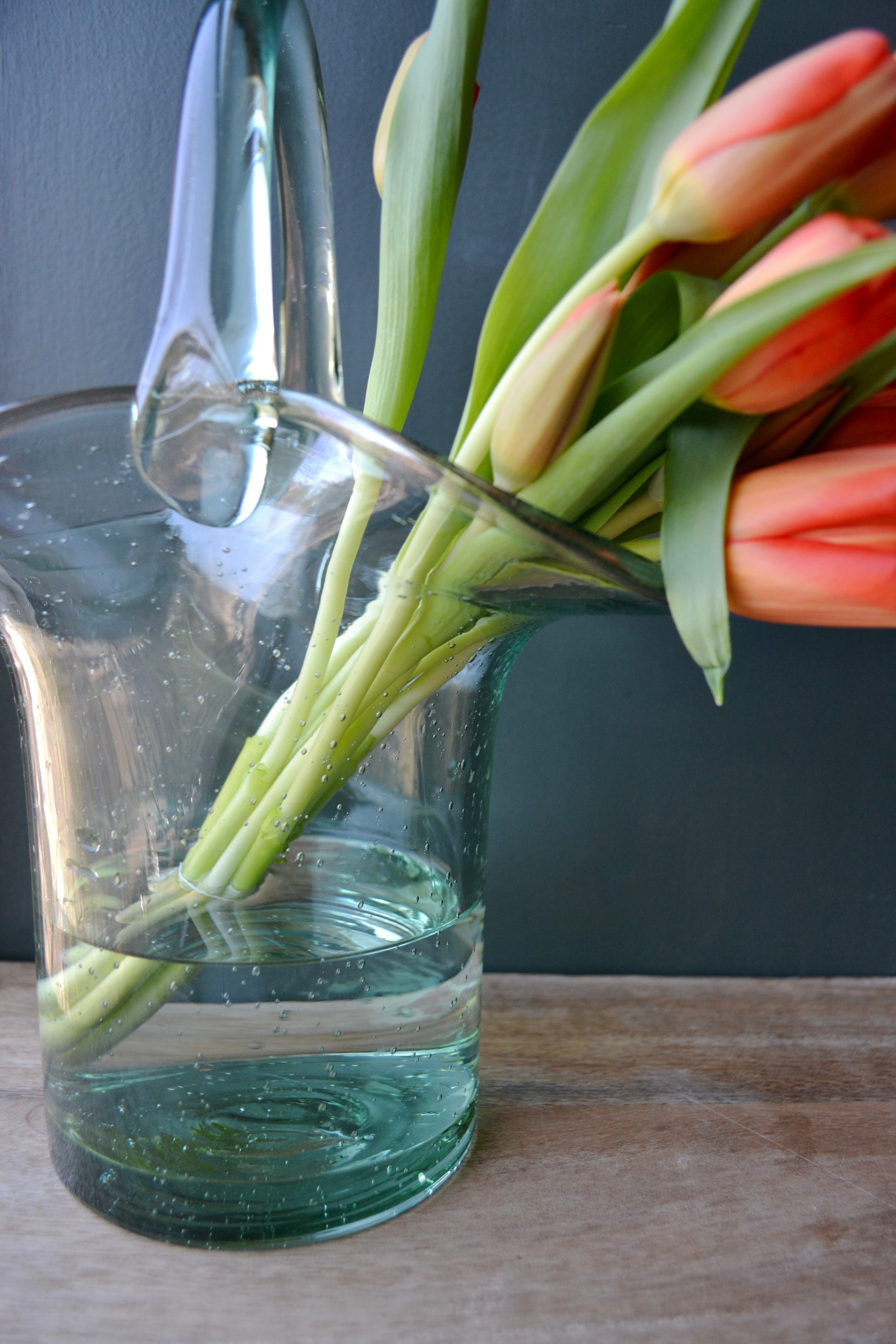 Purse vase, clear vase, purse flower vase, handbag vase, vase with handle, coffee table decor, handmade vase, glass vase, profile view.